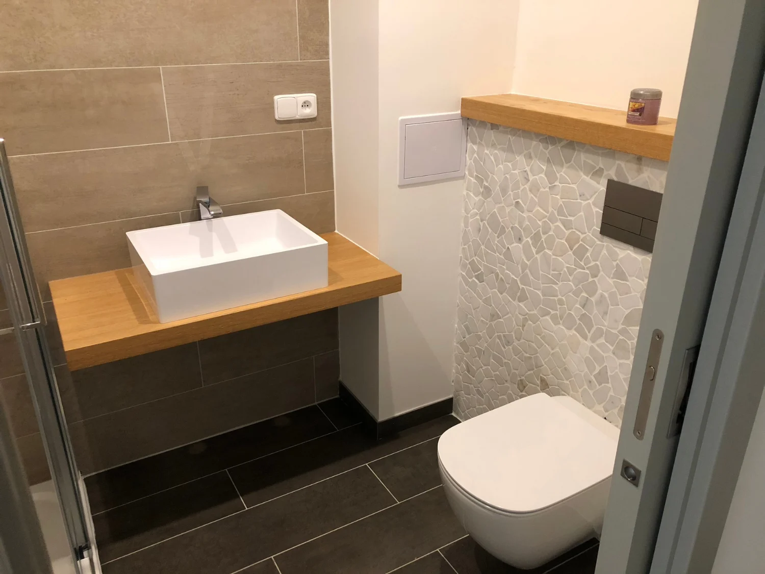 Moderní koupelna s umyvadlem na desce a závěsným WC